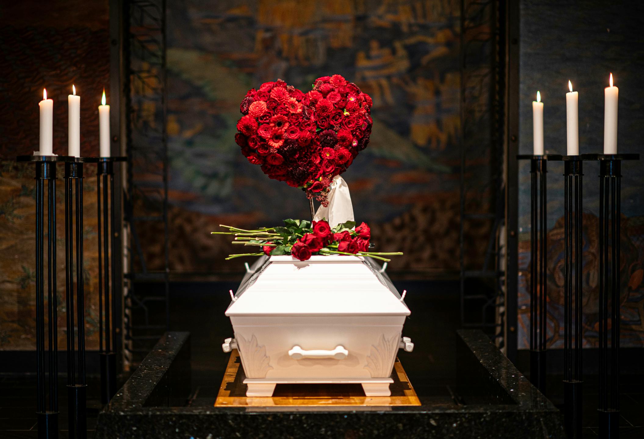 En hvit kiste med roser på toppen